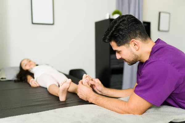 Homem Hispânico Fazer Uma Massagem Aos Pés Uma Menina Clínica — Fotografia de Stock