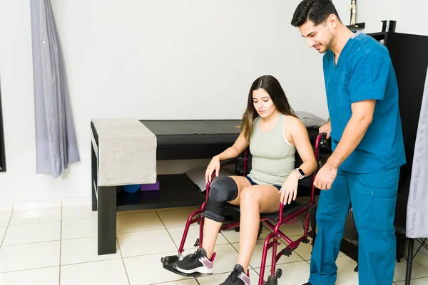 Traurige Attraktive Frau Rollstuhl Der Klinik Lateinamerikanischer Physiotherapeut Hilft Einem — Stockfoto