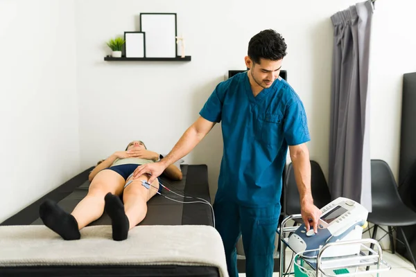 Relaxa Bonito Fisioterapeuta Ligando Uma Máquina Eletroterapia Para Tratar Paciente — Fotografia de Stock