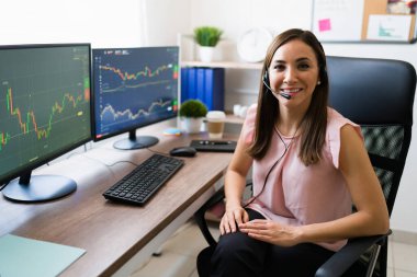 Borsacı olarak çalışmaktan mutluyum. Çalışma masasında oturan genç ve çekici bir kadının portresi. 