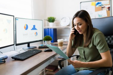 İyi satışlar. Çekici satış temsilcisi bir müşteriyle telefonda konuşurken iş sözleşmesini okuyor. 