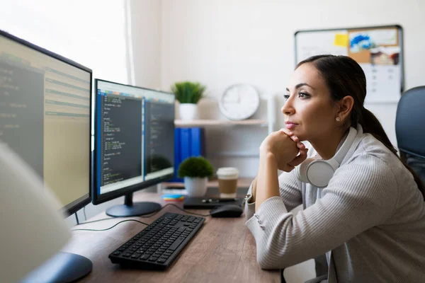 コンピュータ上で読み書きをする若い女性に焦点を当てた 自宅で働いているフリーランスのプログラマーの側面図 — ストック写真