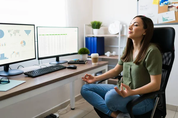 ストレスを避けるための瞑想 リラックスした若い女性瞑想で穏やかな音楽とともに彼女の仕事机の前に座って — ストック写真