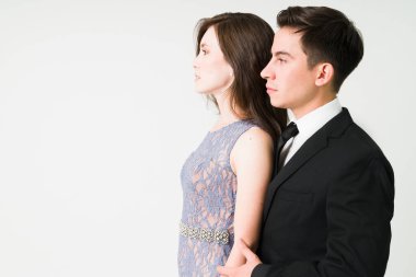 Ufuk çizgisine bakan romantik, beyaz bir çiftin profili. Güzel bir genç kadın ve erkek süslü bir randevuda.