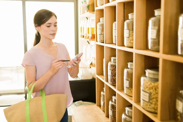 Aantrekkelijke Jonge Vrouw Zoek Naar Haar Boodschappenlijstje Markering Van Items — Stockfoto