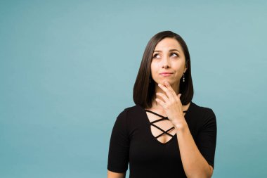 Hayal gücü olan düşünceli genç bir kadın gelecek için planlarını ve fikirlerini düşünüyor.