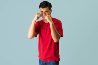 Kızgın genç adam bir kavgaya girmek istiyor. Latin adam yumruklarıyla birine vurmaya hazır.