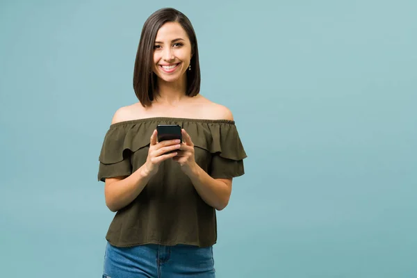 Retrato Uma Mulher Latina Atraente Segurando Seu Smartphone Enquanto Mensagens — Fotografia de Stock