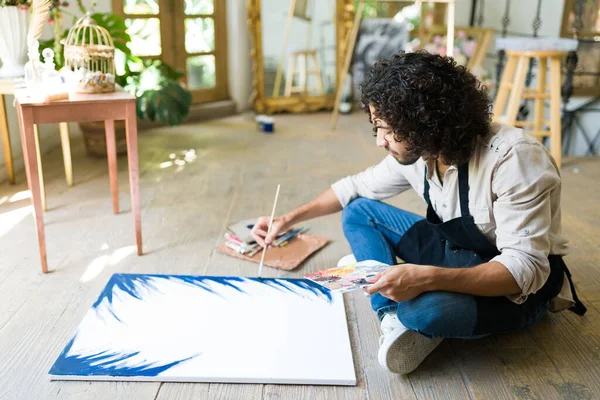 Латиноамериканец Сидящий Полу Студии Начинающий Рисовать Картины Пустом Холсте — стоковое фото
