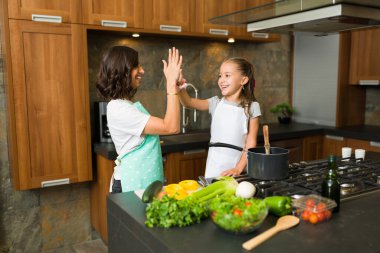 Güzel anne ve kız beşlik çakıyor ve yemeği birlikte hazırladıktan sonra kutluyorlar.