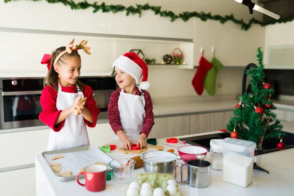 Küçük kız ve oğlan, Noel 'de mutfakta kurabiye hamuru karıştırırken eğlenirken gülüyorlar.