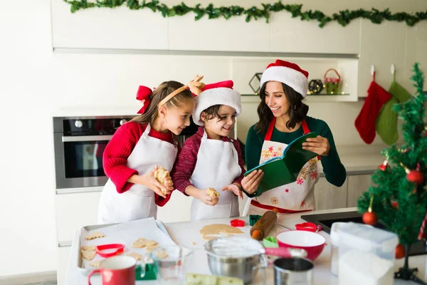 おいしい砂糖クッキーを焼くクリスマスのために開始するレシピ本を読む愛らしい白人の家族 — ストック写真