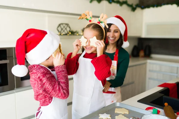 キッチンでクリスマスクッキーと遊んでいる陽気な兄弟 焼きながらママと楽しいです男の子と女の子 — ストック写真