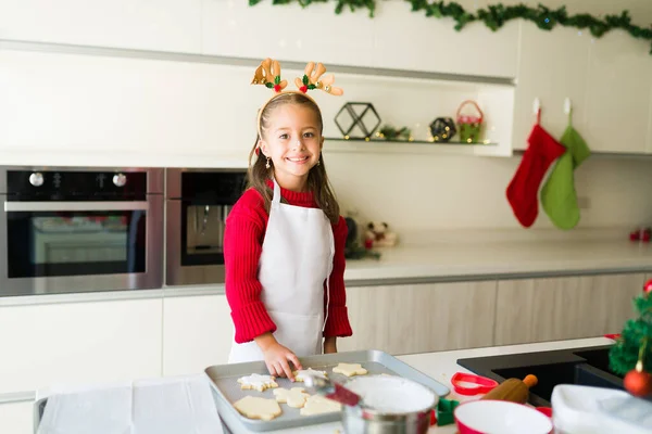 愛らしい美しい女の子笑顔と作る目の接触ながら焼き伝統的なクリスマスクッキー — ストック写真