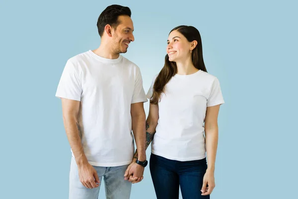在爱情中微笑的年轻夫妇面对面的穿上白色相衬的T恤 喜欢新的印花T恤衫 — 图库照片