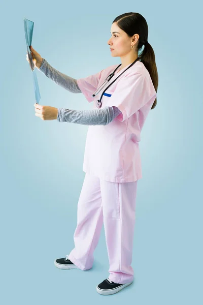 Profesjonalna Młoda Pielęgniarka Różowym Fartuchu Patrząc Skan Kości Pacjenta — Zdjęcie stockowe