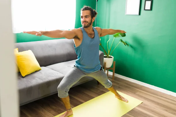 Jovem Bonito Praticando Uma Pose Ioga Guerreiro Sua Sala Estar — Fotografia de Stock