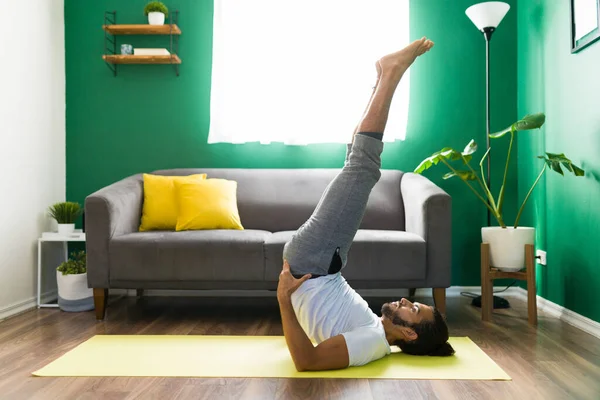 Aktiver Hispanischer Mann Der Seinem Wohnzimmer Einen Gestützten Schulterstand Praktiziert — Stockfoto