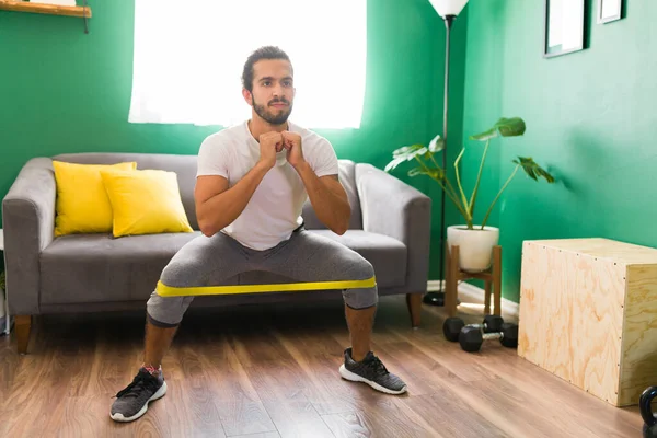 Joven Fuerte Haciendo Sentadillas Usando Una Banda Resistencia Sus Piernas — Foto de Stock