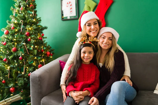 Multiracial happy family looking at the camera and smiling for a picture while celebrating Christmas at home