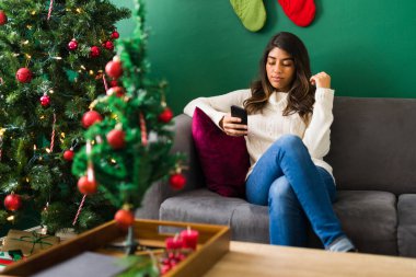 Arkadaşlarıma mesaj atıyorum. Harika bir kadın akıllı telefonunu kullanarak evde ailesiyle bir Noel partisi hazırlıyor.