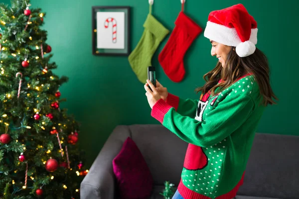 Sevimli Genç Bir Kadın Süslü Noel Ağacının Akıllı Telefonuyla Fotoğraf — Stok fotoğraf