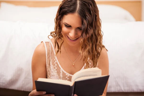 Χαμογελαστή γυναίκα ανάγνωση στο σπίτι — Φωτογραφία Αρχείου
