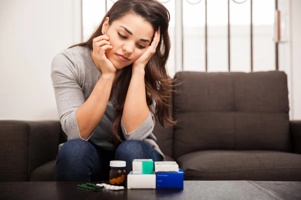 Overwhelmed woman with assorted medicines — Stock Photo, Image