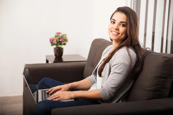 Vrouw met laptop op een bank — Stockfoto