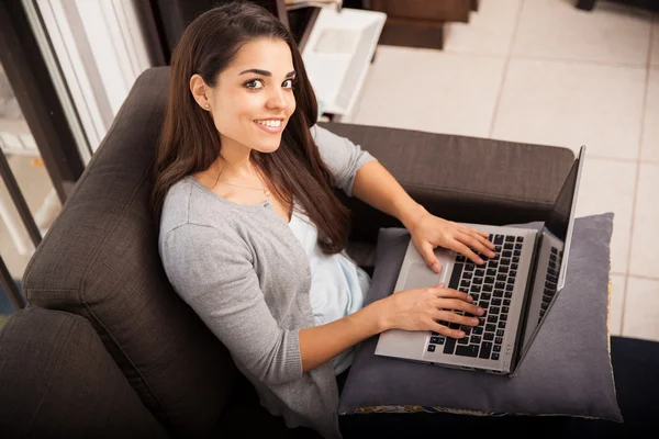 Mulher com laptop em um sofá — Fotografia de Stock