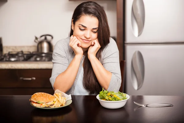 Mulher com fast food e salada — Fotografia de Stock