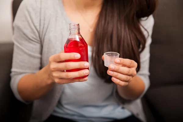 Vrouw handen met hoestsiroop — Stockfoto