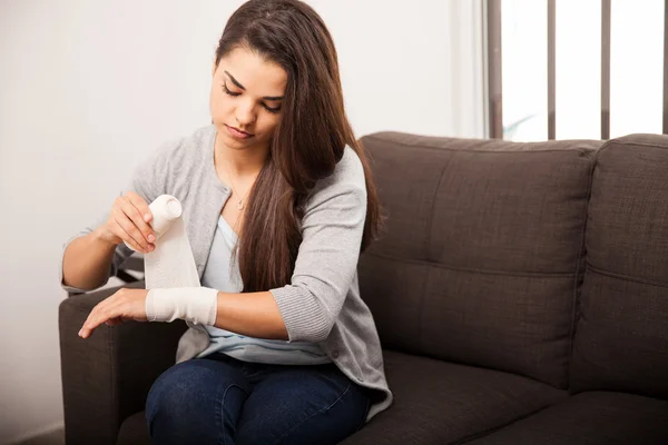 Frau bandagiert ihren Arm — Stockfoto