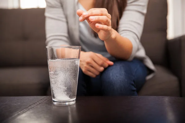 Manos con píldora y vaso de agua — Foto de Stock