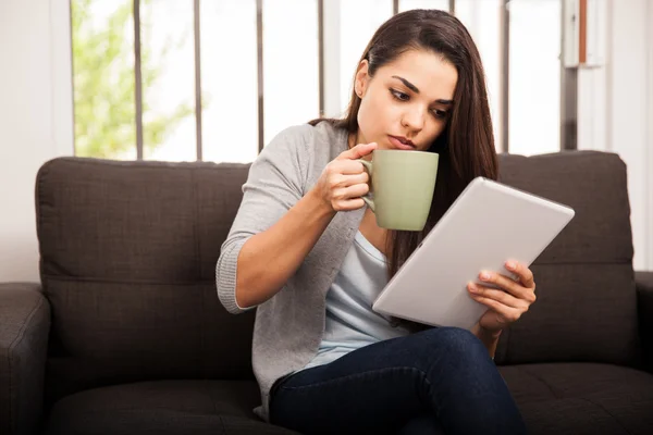 Frau mit Tablette und heißem Becher — Stockfoto