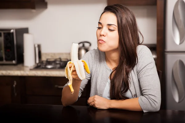 Hispanische Frau isst eine Banane — Stockfoto