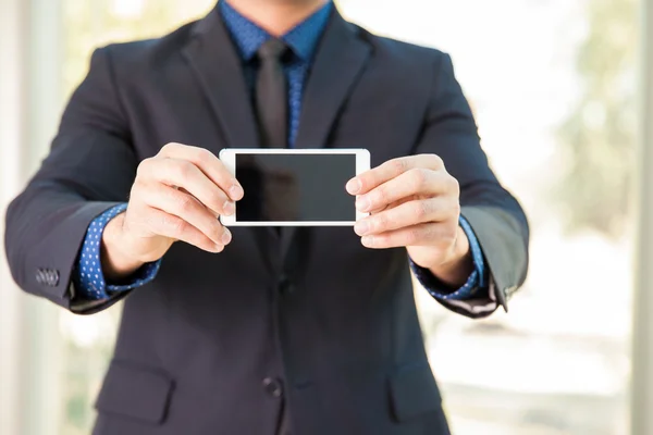 Businessman showing smart phone screen — Stock Photo, Image