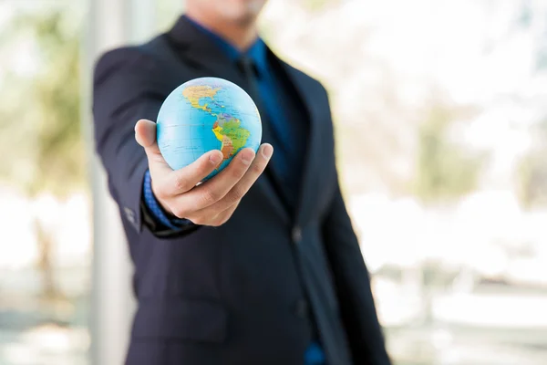 Businessman holding globe in hand — Stock Photo, Image