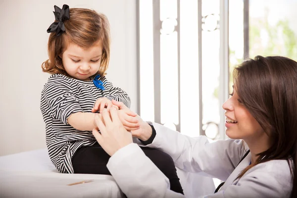 Kinderarts toepassing een bandage — Stockfoto