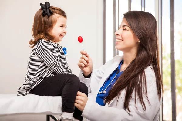 Kinderarzt gibt einen Lutscher — Stockfoto