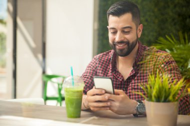 Genç adam akıllı telefon kullanıyor.