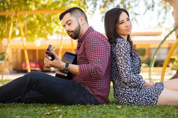 Пара, играющая на гитаре и поющая — стоковое фото