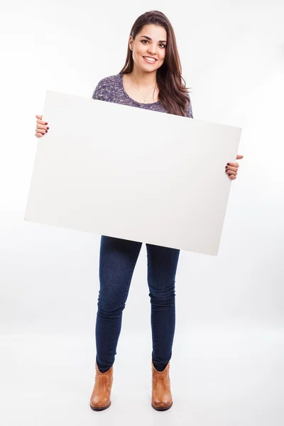 Brunette holding a big  sign — Stock Photo, Image