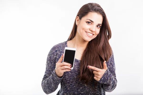 Brünette zeigt auf Smartphone — Stockfoto