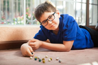 Boy in glasses lying on the carpet clipart
