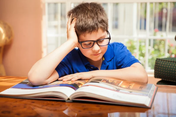 Kleiner Junge liest ein großes Buch — Stockfoto