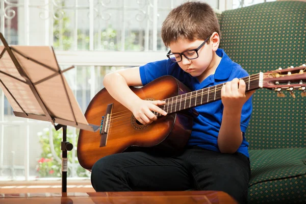 Enfant pratiquant quelques accords de guitare — Photo