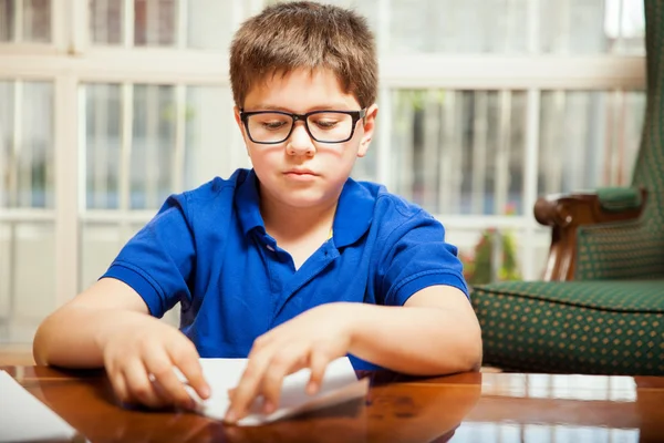 Boy  folding a sheet of paper — Stock Photo, Image