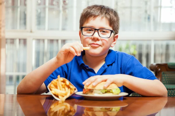 Pojken äta pommes frites — Stockfoto