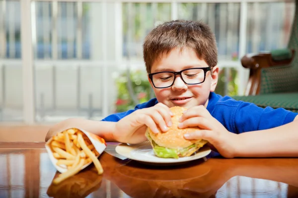 Rapaz está prestes a comer um hambúrguer — Fotografia de Stock